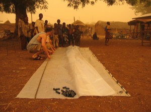 100 mile per hour wind resistant greenhouse plastic cover we brought with us. Note the homemade clips made by splitting flexible black pipe.